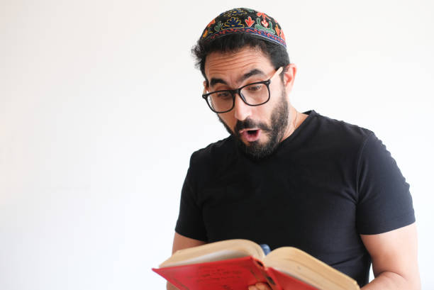 istock Jewish man reading the torah in a red book 1356240978