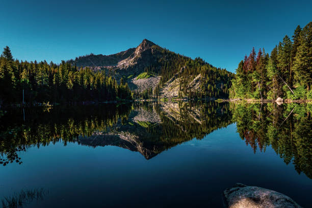 Louie Lake A sunny morning hiking destination in the Idaho Wilderness with a beautiful mountain reflection on a glassy lake. idaho stock pictures, royalty-free photos & images