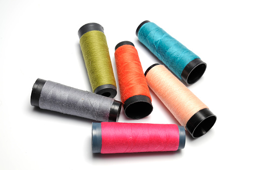 Accessories for sewing and needlework. Many multi-colored spools of thread. Bobbins with colored thread