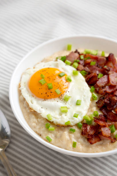 istock Homemade Cheesy Bacon Savory Oatmeal Bowl on cloth, low angle view. 1356244816