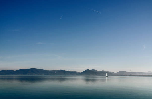 lake trasimeno , italy with sail boat - reflection imagens e fotografias de stock