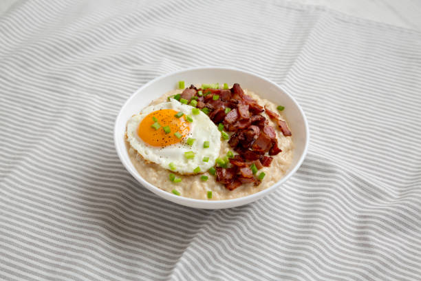 istock Homemade Cheesy Bacon Savory Oatmeal Bowl on cloth, low angle view. 1356244855
