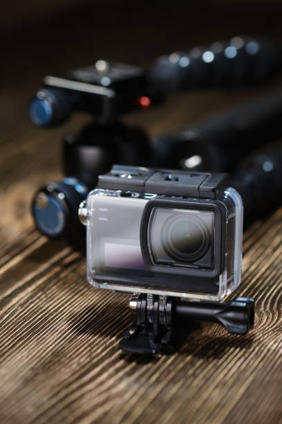 istock Black action camera on brown wooden tabletop. 1356245320