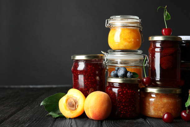 jars with different jams and fresh fruits on black wooden table - raspberry table wood autumn imagens e fotografias de stock