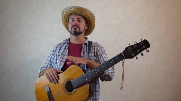 istock A man in a hat with his hands knocks on a guitar 1356246568