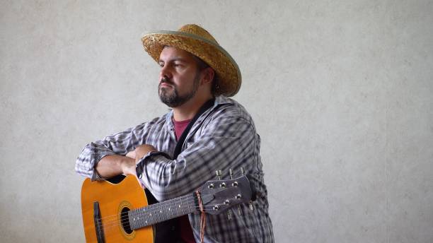 istock A man in a straw hat sits with a guitar 1356246666