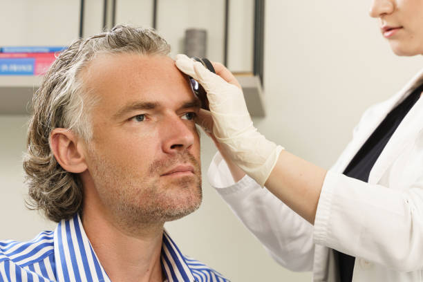 istock Dermatologist is using dermatoscope for facial skin examination. 1356248046