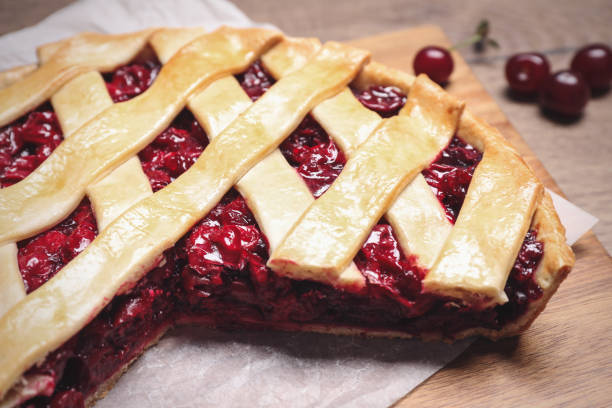 istock Delicious fresh cherry pie on wooden board, closeup 1356250552