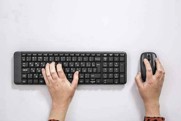 Female hands use the keyboard and mouse on a white background.