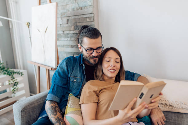 istock Happy couple reading a book and enjoying together 1356257146