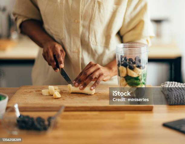 Close Up Of Woman Hands Cutting Banana On A Cutting Board Stock Photo - Download Image Now