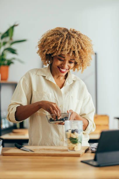 Smiling Woman Making Healthy Breakfast in the Kitchen