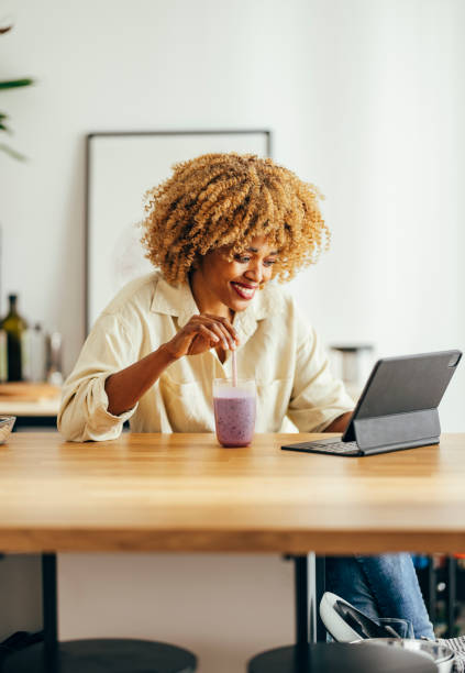 istock Smiling Woman Using Digital Tablet at Home 1356258315