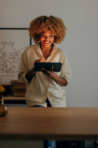 istock Portrait of Smiling Woman Using Digital Tablet at Night 1356258363