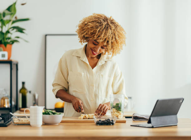 istock Smiling Woman Making Healthy Breakfast in the Kitchen 1356258383