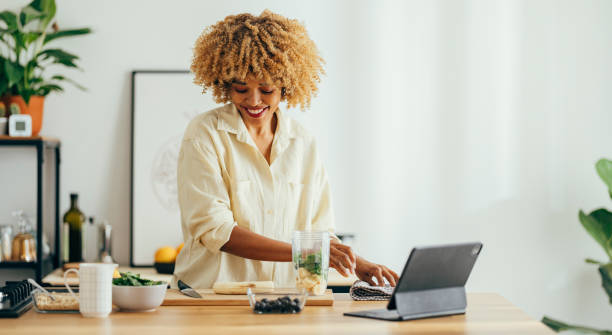 istock Smiling Woman Making Healthy Breakfast in the Kitchen 1356258384