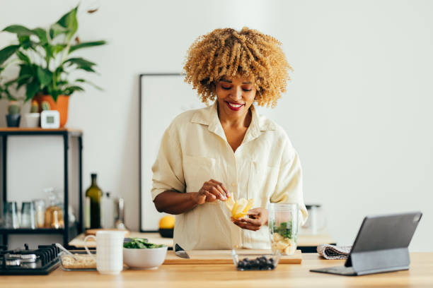 istock Smiling Woman Making Healthy Breakfast in the Kitchen 1356258386