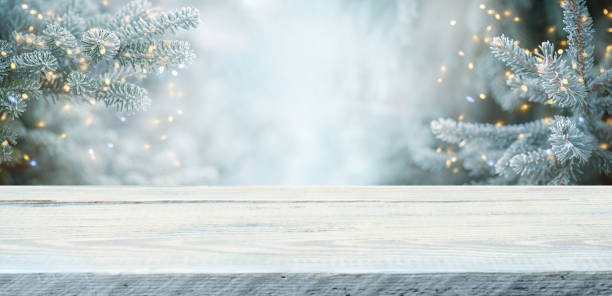 istock Wood table top on  christmas tree background 1356258485
