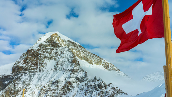 The view point from Jungfraujoch with the swiss flag in the foreground.