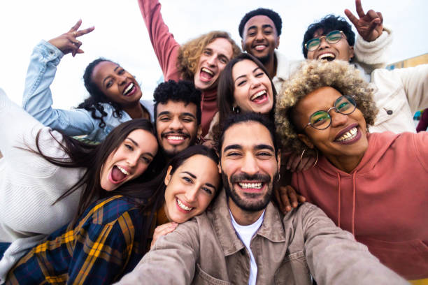 Big group portrait of diverse young people together outdoors stock photo