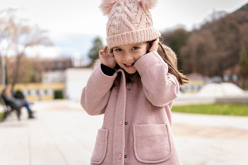 Cheerful child wearing a stylish coat smiling on autumn day