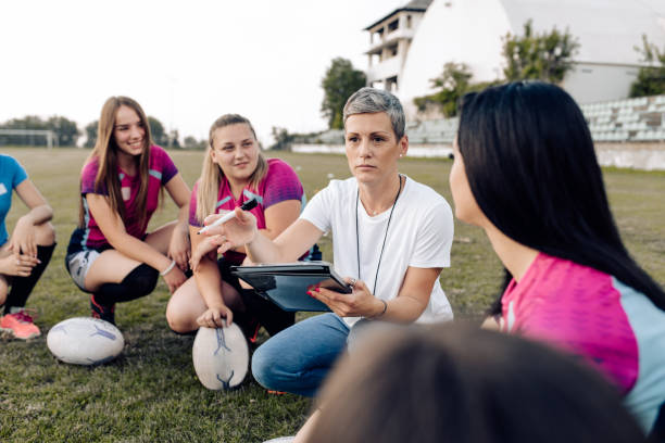 istock Female rugby coach making a play strategy with her team 1356263087