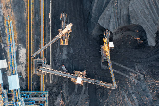 istock Territory of the coal terminal with coal dumps and a regenerator. loading and unloading of coal by excavators and belt conveyors. coal reserves at thermal power plants. View from above 1356269221