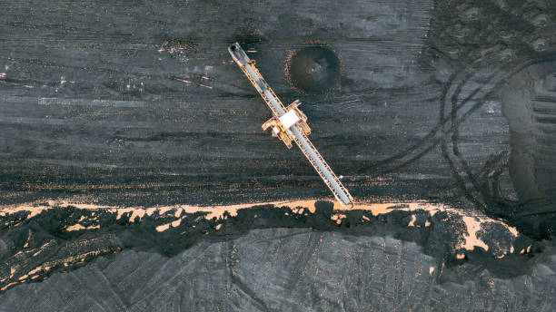 istock Territory of the coal terminal with coal dumps and a regenerator. loading and unloading of coal by excavators and belt conveyors. coal reserves at thermal power plants. View from above 1356269254