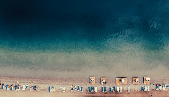 Perfect dark blue cinematic  beach and sunshades top view of aegean sea at Muğla turkey