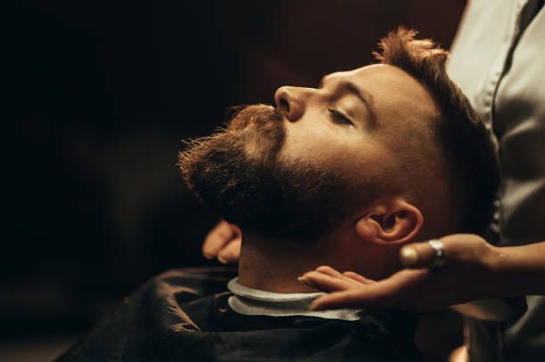 彼は理髪店に座っている間、若い男のひげを閉じる - fashion male beauty confidence elegance ストックフォトと画像