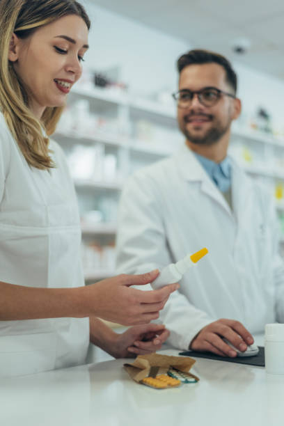istock Young female pharmacist holding medications in her hand 1356272692