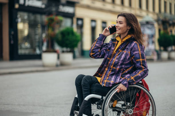 istock Woman with disability using a smartphone while out in the city 1356272699