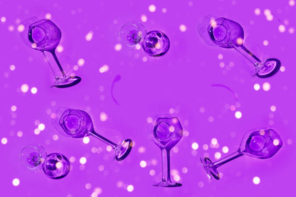 istock Glasses with white wine or champagne on violet background. Flat lay style. 1356273722