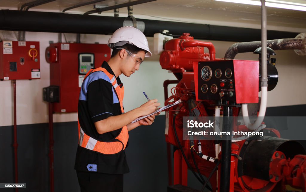 Young engineer check fire suppression system in control room of factory , daily check job of maintenance technician Young engineer check fire suppression system at conrol room of factoryYoung engineer check fire suppression system in control room of factory , daily check job of maintenance technician Fire - Natural Phenomenon Stock Photo