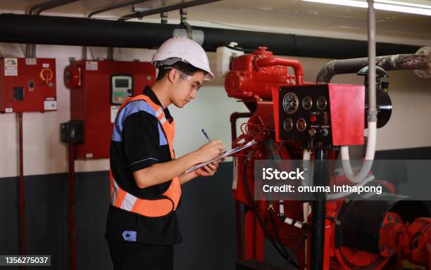 Young Engineer Check Fire Suppression System In Control Room Of Factory Daily Check Job Of Maintenance Technician Stock Photo - Download Image Now