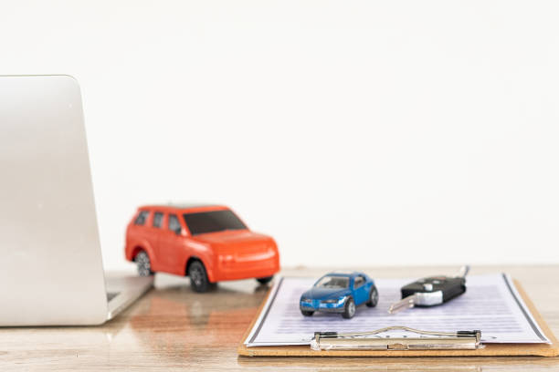 istock car and notebook Contract documents with keys on the table, selling and renting ideas. 1356277908
