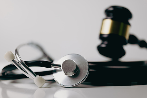 Stethoscope and gavel on white background, symbol of law and medic
