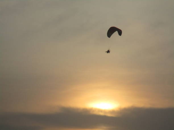 istock Paragliding flying at sunset 1356280380