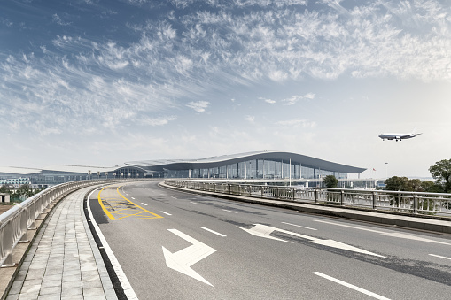 modern airport view, road to terminal with airplane against a blue sky
