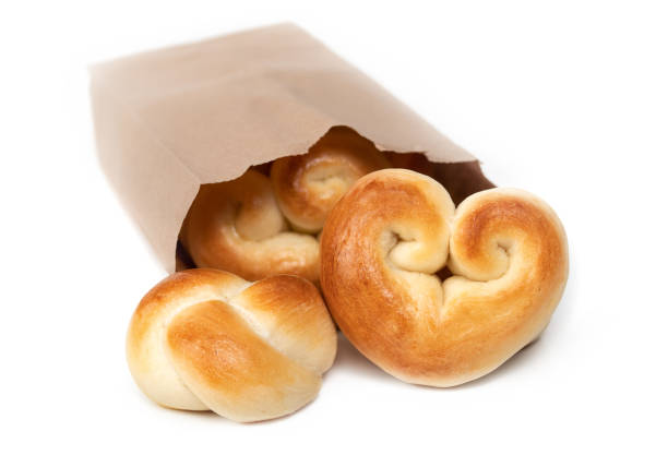 Single portion yeast bread buns. Concept for valentines day or baking with love. Traditional Swiss butter bread called Zopf or Challah. Isolated on white.