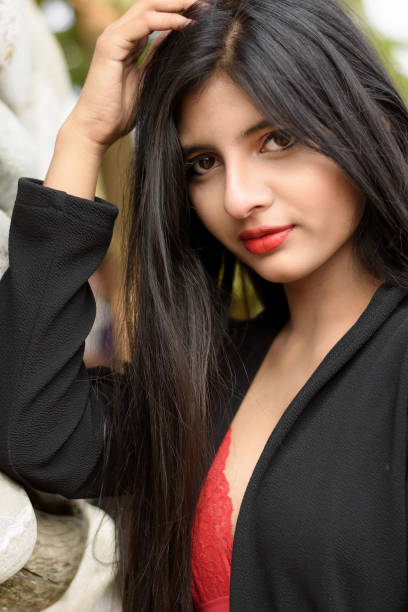 Portrait of very beautiful young attractive woman wearing red outfit with black jacket posing fashionable in a blurred background. Lifestyle and Fashion. stock photo
