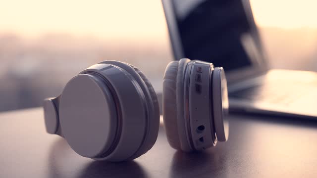 Headphones with laptop on wooden table