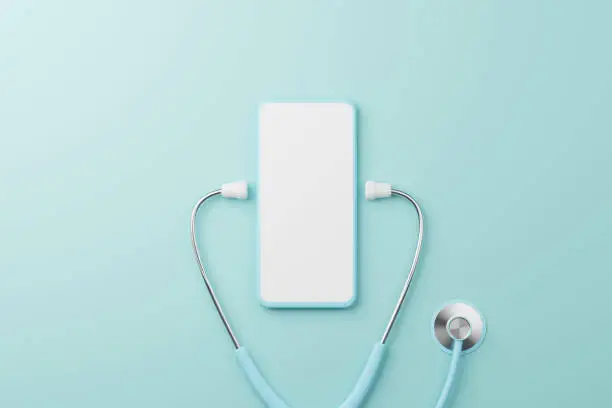 Photo of Top view of medical stethoscope and mobile smartphone blank screen on cyan background. Health care insurance and health technology innovation online telemedicine. 3d rendering