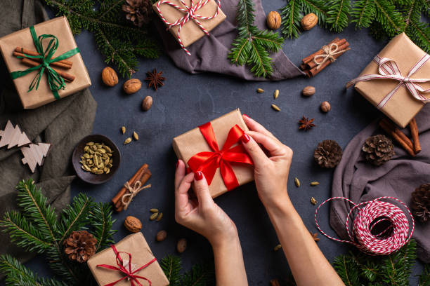 istock Christmas concept, female hands wrapping handmade eco friendly gift boxes 1356308368