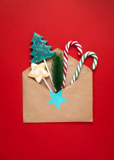 istock lollipop in an envelope on a red background. 1356308434