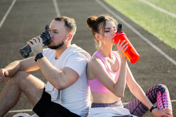 istock Young athletes after training sit and drink water at the stadium 1356312735