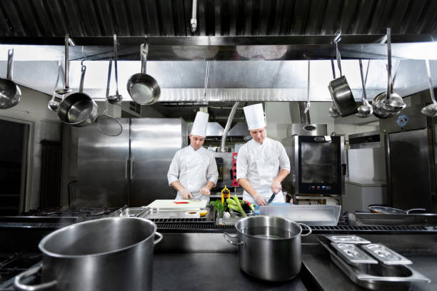 chefs prepare meals in the kitchen - storkök bildbanksfoton och bilder