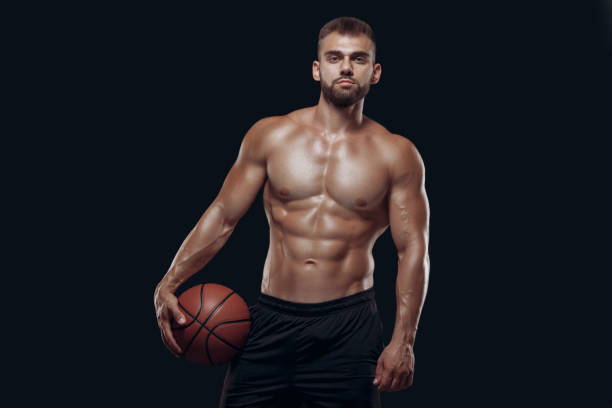 retrato de um homem nu muito musculoso jogando basquete isolado no fundo negro - shirtless strength sensuality black - fotografias e filmes do acervo