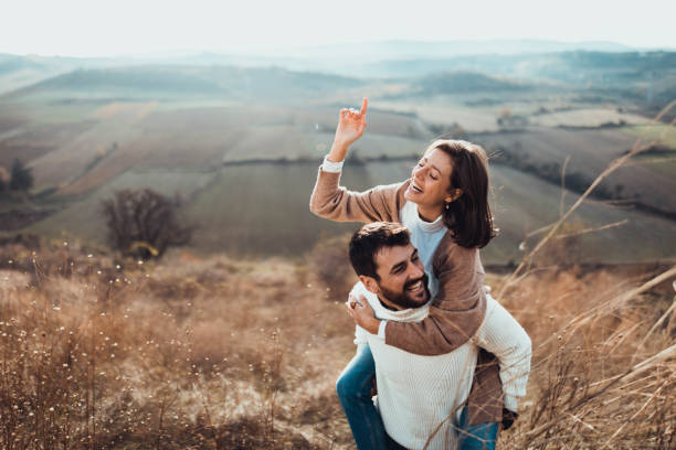 istock Young cheerful couple having fun while piggybacking on a hill. 1356316848