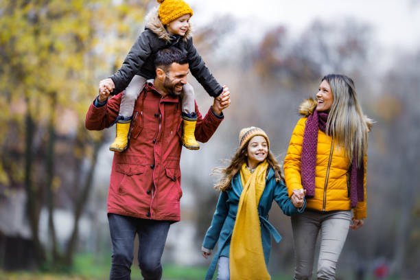 istock Happy family having fun while running in autumn day. 1356318692